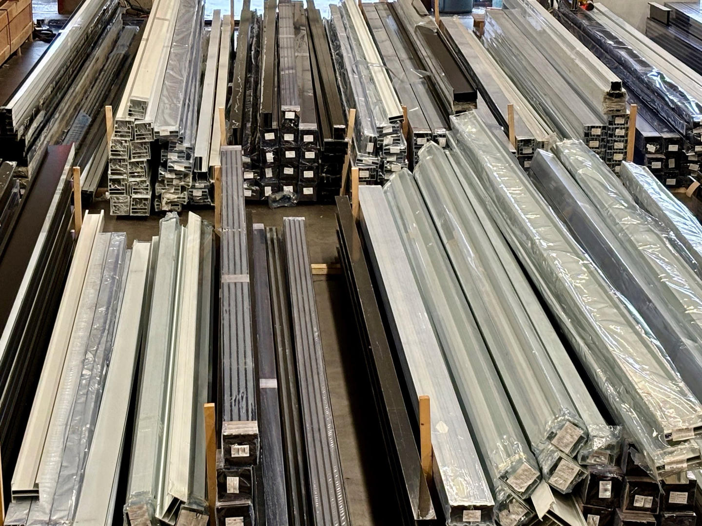 A stack of aluminum beams on a warehouse floor